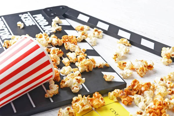 Caramel popcorn and movie clapper — Stock Photo, Image