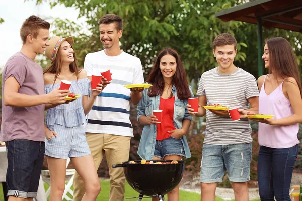 Young friends having barbecue party in garden