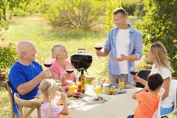 Lykkelig familie som har grillfest utendørs – stockfoto
