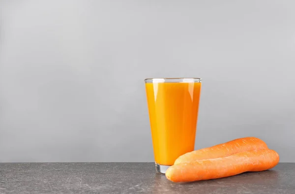 Vaso de jugo de zanahoria fresca en la mesa — Foto de Stock