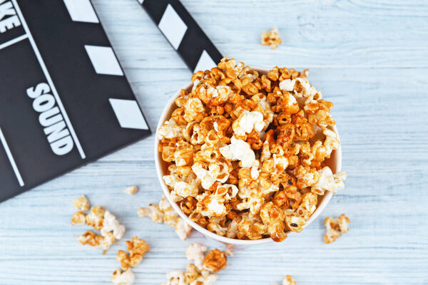 Cup with caramel popcorn and movie clapper 