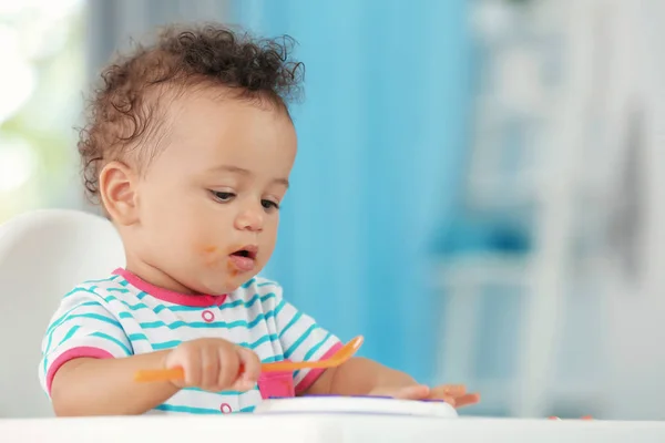 Little baby eating puree indoors — Stock Photo, Image