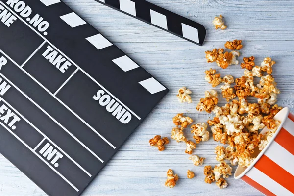 Gobelet en papier avec pop-corn au caramel et film clapper — Photo