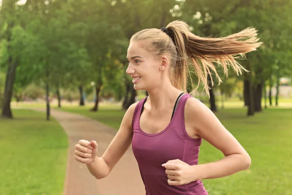 Jeune femme courant dans le parc — Photo