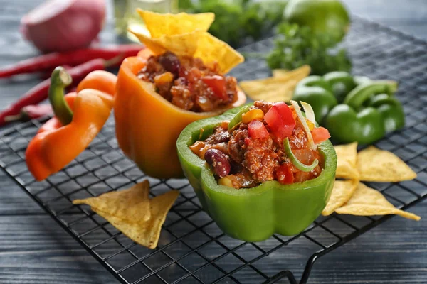 Stuffed peppers with chili con carne and nacho chips on metal grid — Stock Photo, Image