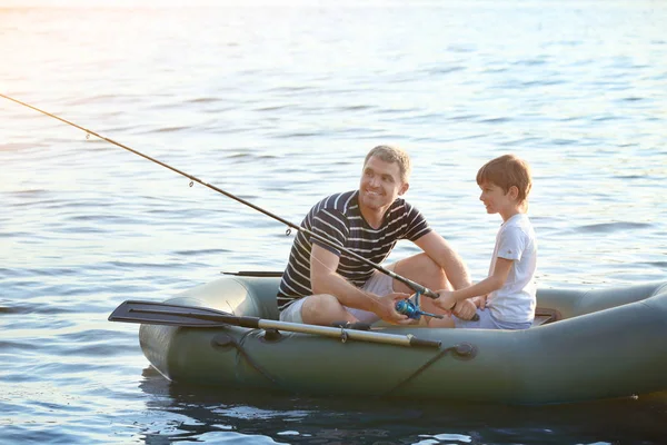 Father with son fishing from boat on river — Stock Photo, Image