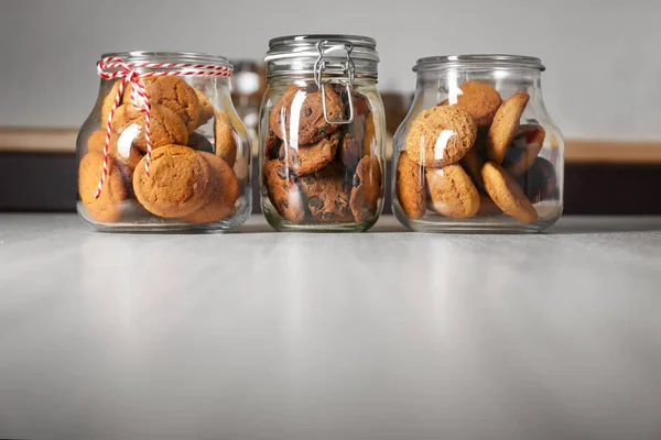 Glass jars with delicious oatmeal cookies — Stock Photo, Image