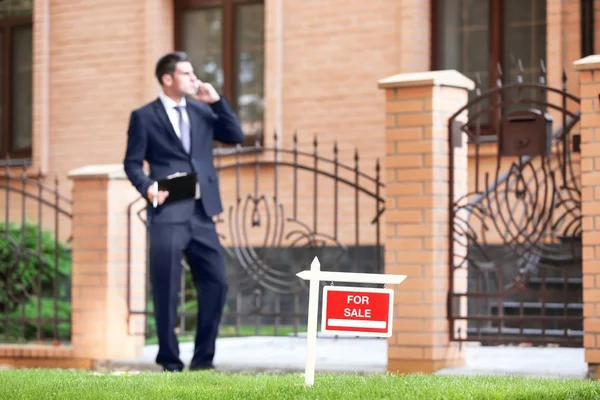 "For sale" sign and real estate agent near house — Stock Photo, Image