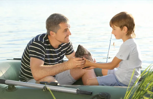 Padre con hijo pescando desde el barco en el río — Foto de Stock