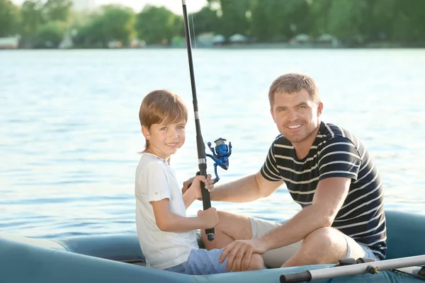 Otec se synem rybolov z lodi na řece — Stock fotografie