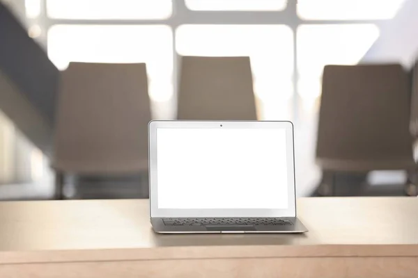 オフィスのテーブルの上に空白の画面を持つ現代のラップトップ — ストック写真