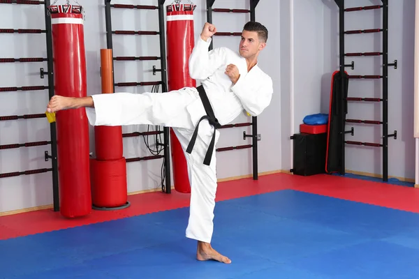 Młody człowiek ćwiczyć karate w dojo — Zdjęcie stockowe