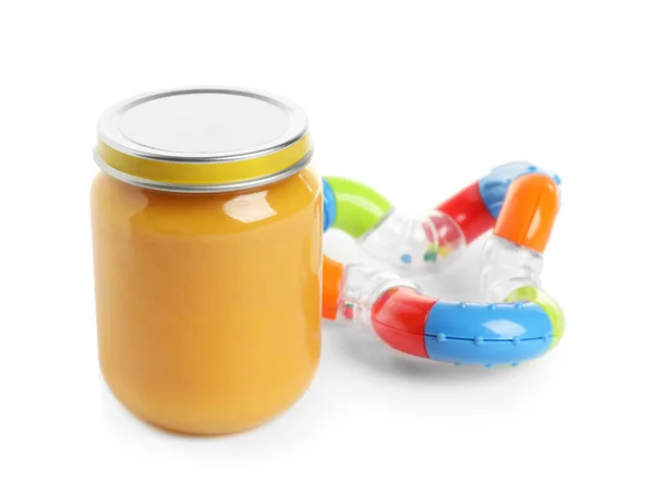 Jar with yummy baby food and rattle — Stock Photo, Image