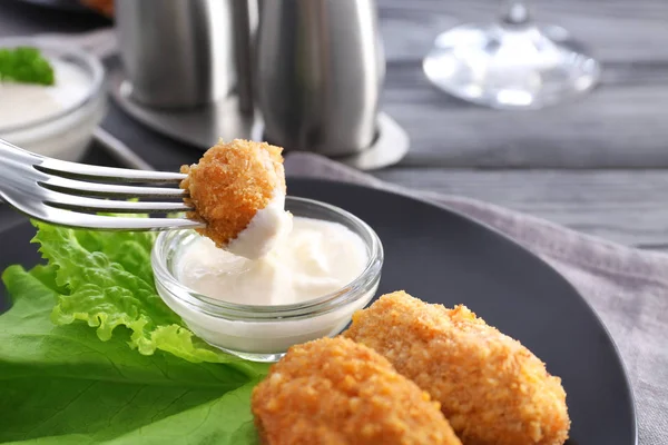 Dipping piece of salmon croquette — Stock Photo, Image
