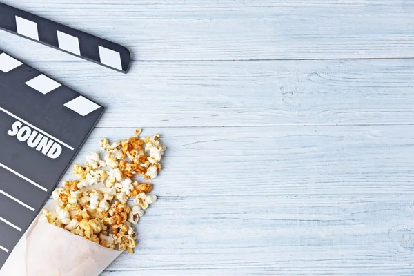 Papieren conus met karamel popcorn en film klepel — Stockfoto