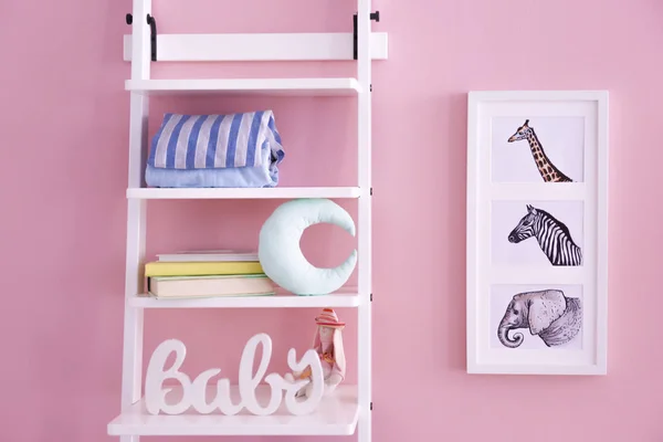 Rekken met speelgoed en foto's van dieren op de muur in de kamer van de baby — Stockfoto