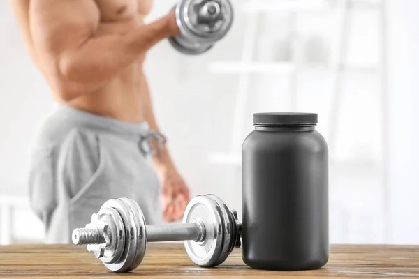 Dumbbell and jar with protein powder