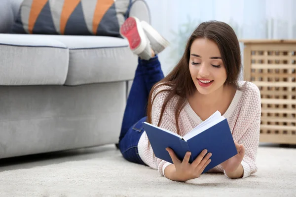 Молодая женщина читает книгу на полу — стоковое фото