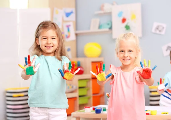 Cute girls with painted palms indoor — Stock Photo, Image