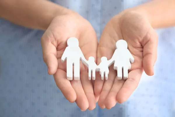 Mujer sosteniendo figura de familia — Foto de Stock