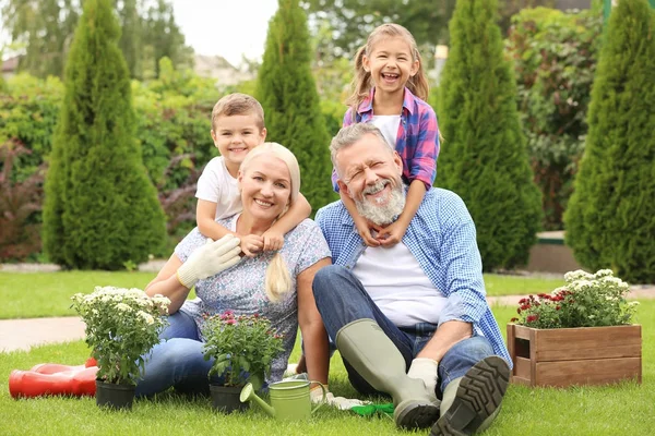 Bejaarde echtpaar met kleinkinderen in tuin — Stockfoto