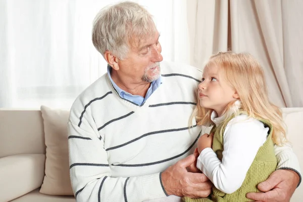 Oudere man met kleindochter thuis — Stockfoto