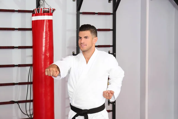 Młody człowiek ćwiczyć karate w dojo — Zdjęcie stockowe