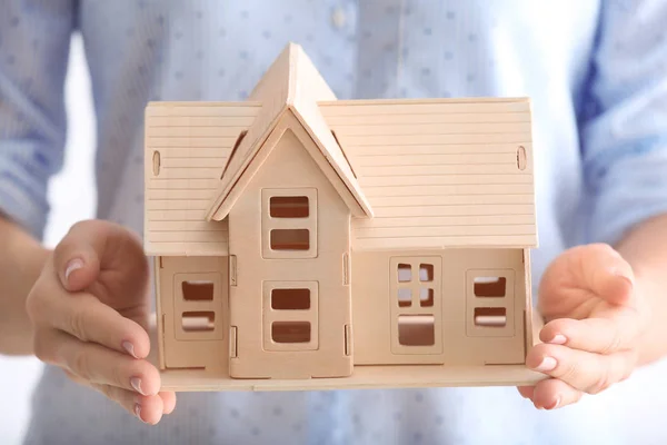 Woman holding wooden house — Stock Photo, Image