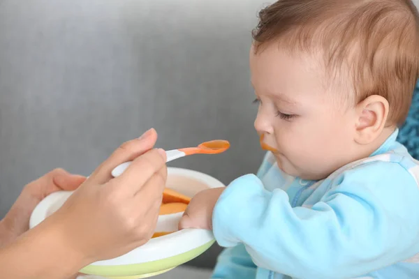 Mutter füttert Baby mit Löffel im Haus — Stockfoto