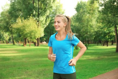 Genç bayan parkta koşuyor.