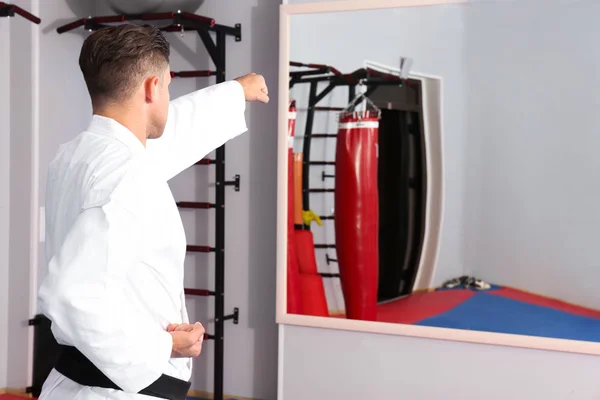 Young man practicing karate in dojo — Stock Photo, Image