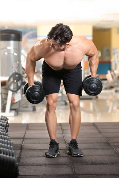 Muskulöser junger Mann beim Training im Fitnessstudio — Stockfoto