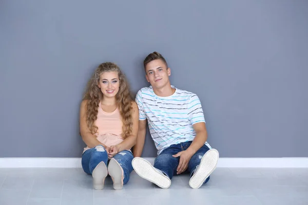 Young couple sitting on floor in room at new home — Stock Photo, Image