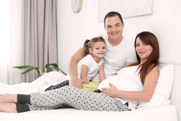 Felice giovane famiglia sul letto a casa — Foto Stock