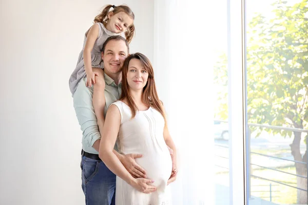 Felice giovane famiglia vicino alla finestra — Foto Stock