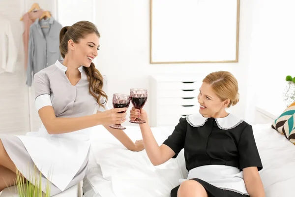 Beautiful chambermaids drinking wine — Stock Photo, Image