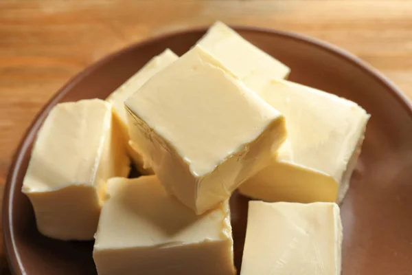 Plate with cubes of butter on table — Stock Photo, Image