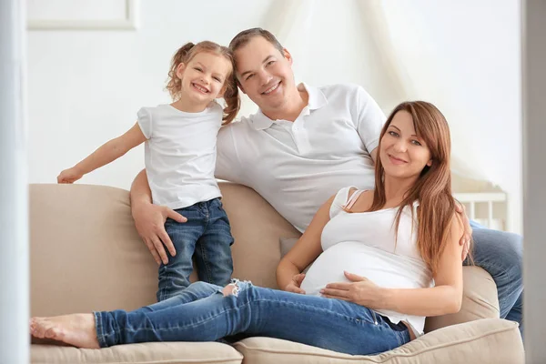 Felice giovane famiglia sul divano di casa — Foto Stock