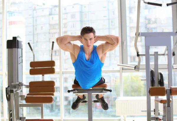 Musclé jeune homme s'entraînant dans la salle de gym — Photo