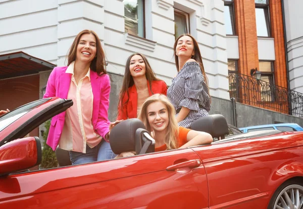 Beautiful young women in cabriolet outdoors