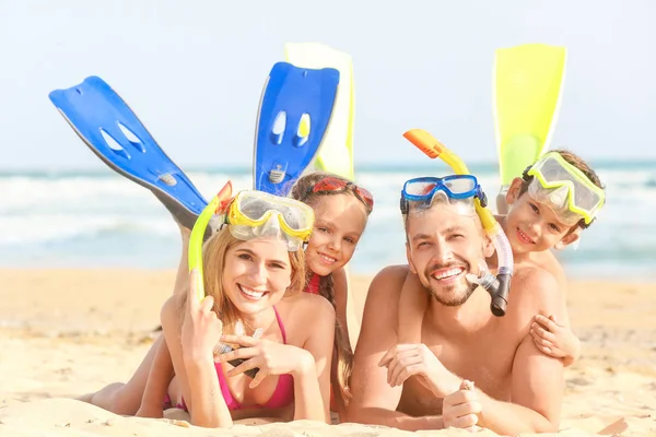 Щаслива сім'я з веслами та снорклінговими масками на морському пляжі на курорті — стокове фото