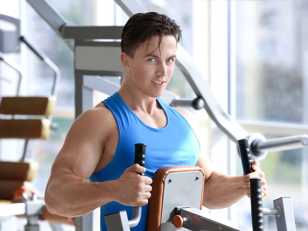 Musculoso joven entrenamiento en el gimnasio — Foto de Stock