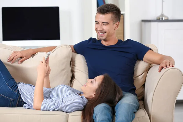 Молодая пара на диване дома — стоковое фото