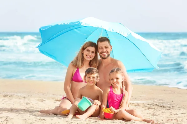 Família feliz na praia do mar no resort — Fotografia de Stock