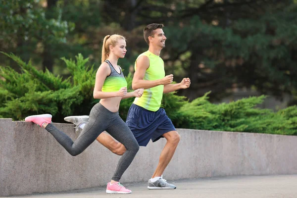 Pareja joven en ropa deportiva haciendo ejercicios en la ciudad — Foto de Stock