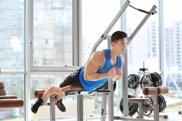 Muskulöser junger Mann beim Training im Fitnessstudio — Stockfoto