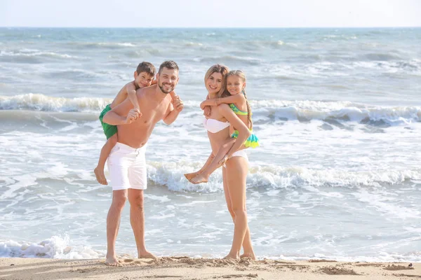 Šťastná rodina na mořské pláži v letovisku — Stock fotografie
