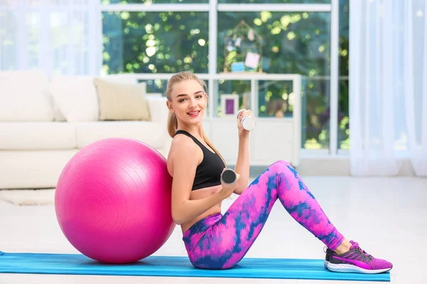 Mujer joven en ropa deportiva haciendo ejercicios en interiores —  Fotos de Stock