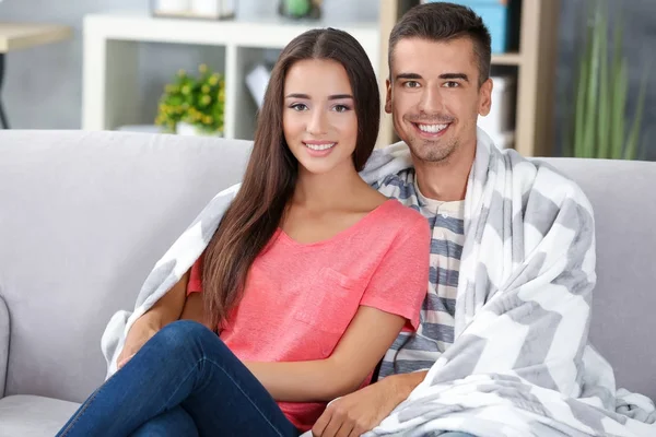 Jeune couple sur canapé à la maison — Photo