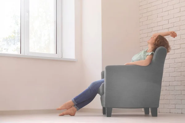 Молода жінка відпочиває в кріслі вдома — стокове фото